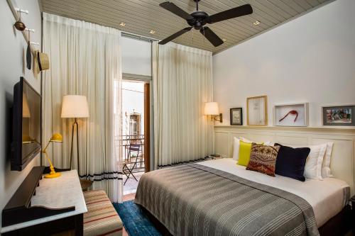 a bedroom with a bed and a ceiling fan at Market House - An Atlas Boutique Hotel in Tel Aviv