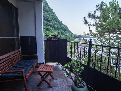 a balcony with a bench and a view of a mountain at ISANA Resort in Ito