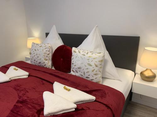 a bedroom with a bed with white and red pillows at Prime Host Charme Apartment in Karlsruhe