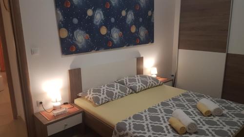 a bedroom with a bed with two lamps and a painting at Orange Brist in Pula