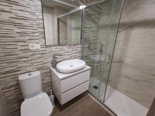 a bathroom with a toilet and a shower and a sink at Penthouse Avocado with sea view in Finestrat