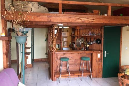 een keuken met een houten bar met 2 krukken bij Repaire de Barberousse de Gruissan in Gruissan
