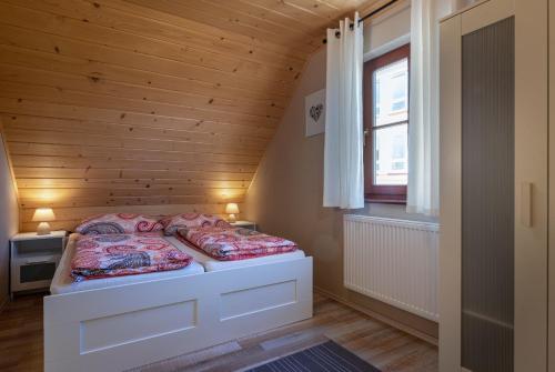 ein kleines Schlafzimmer mit einem Bett in einem Holzzimmer in der Unterkunft FAIRYTAIL sk in Veľký Slavkov