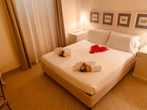 a bed with a white comforter and pillows on it at Hotel San Pietro Palace in Finale Ligure
