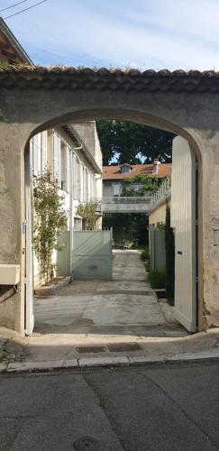 an archway over an alley in a street with buildings at L'Observance Bed & Breakfast in Avignon