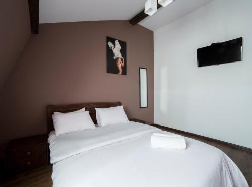 a bedroom with two beds with white sheets at Апартаменти на площі Митній в центрі Львова in Lviv