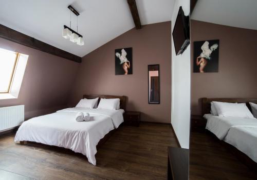 a bedroom with two beds with white sheets at Апартаменти на площі Митній в центрі Львова in Lviv