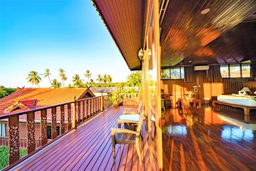 a wooden deck with a bedroom and a bed at Erawan Villa Hotel in Bangrak Beach