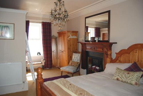 ein Schlafzimmer mit einem Bett, einem Spiegel und einem Stuhl in der Unterkunft Orsay House in Portnahaven