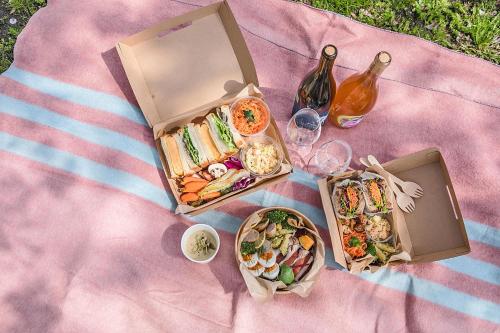 a picnic with two boxes of food and a bottle of wine at Hotel Noum OSAKA in Osaka
