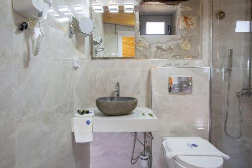 a bathroom with a sink and a toilet at dell Mar stone house in Évyiros