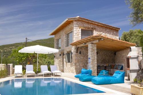 a villa with a swimming pool in front of a house at dell Mar stone house in Évyiros