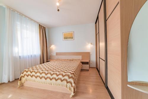 - une chambre avec un lit et une grande fenêtre dans l'établissement SR Apartamentai, à Druskininkai