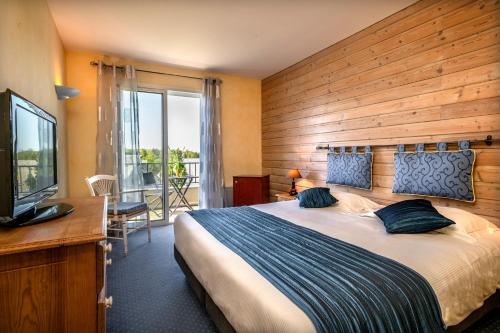 a bedroom with a large bed with a wooden wall at Logis Hôtel Restaurant Gilles Moreau Laguiole in Laguiole