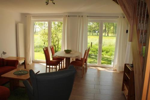 萬格爾蘭的住宿－Ferienhaus Groß Popkenhausen，客厅配有桌椅和窗户。
