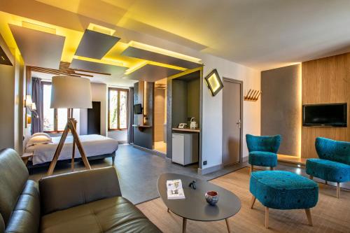 a hotel room with a bed and a living room at Logis Hôtel Restaurant Gilles Moreau Laguiole in Laguiole