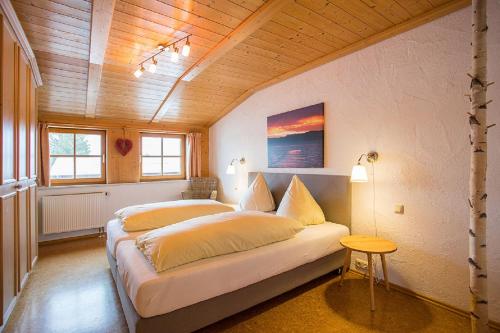 1 dormitorio con 2 camas y techo de madera en Ferienhaus Haußmann, en Schwangau
