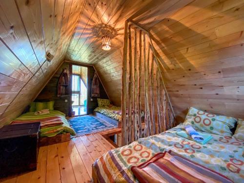 a room with two beds in a wooden cabin at Vikendica Pustolov - Uvac, Zlatar in Nova Varoš