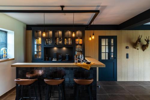 a kitchen with a bar with stools around it at Elvier B&B in Mol