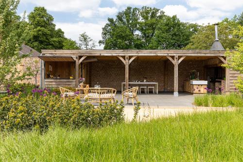 a pavilion with a table and chairs in a garden at Elvier B&B in Mol