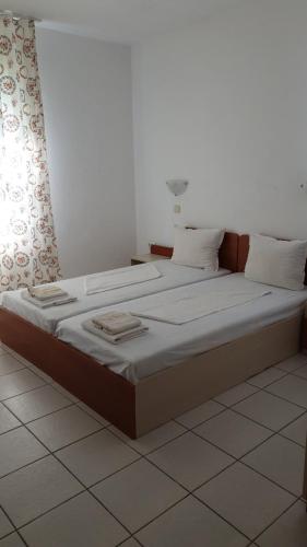 a bedroom with a large bed with white sheets at Майстор Костадин - 1878 in Obzor