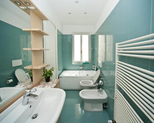 a bathroom with a sink and a toilet and a tub at Bed and breakfast Grim in Trieste