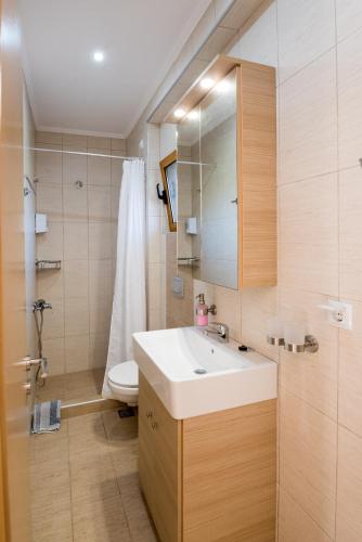 a bathroom with a sink and a toilet at Katerina Hotel in Kanali