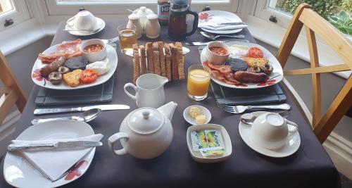 a table with plates of breakfast food on it at Herdwick Guest House in Keswick