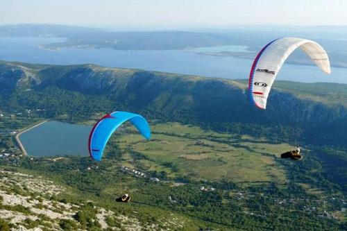 two kites flying in the sky over a lake at Apartments Adriatic in Selce
