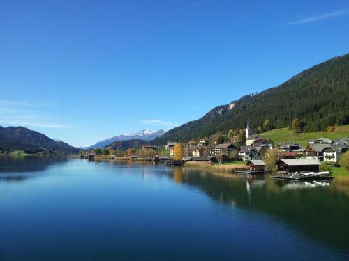 a small town on a river with houses and mountains at Ferienwohnung Waschnig in Greifenburg