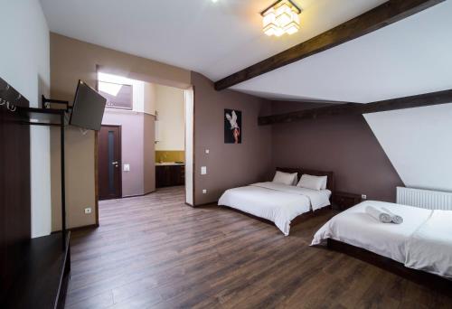 een kamer met 2 bedden en een flatscreen-tv bij Апартаменти в центрі на площі Митній in Lviv