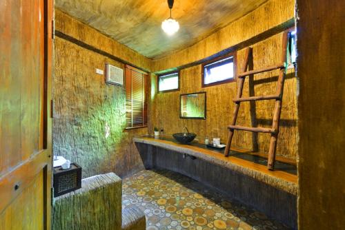 a bathroom with a sink and a ladder in it at Theerama Cottage in Suan Phung