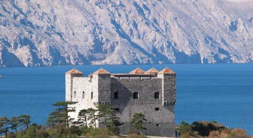 a castle in the middle of a body of water at Apartments Adriatic 2 in Selce