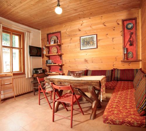 a living room with a table and chairs and a couch at Къща край реката - Триград in Trigrad