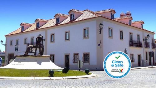 a statue in front of a building with a sign in front at Casa do Largo - Golegã - Turismo de Habitação in Golegã