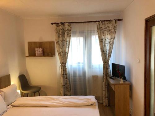 a bedroom with a bed and a window with a monitor at Chalet Il Rifugio Bradet in Săcele