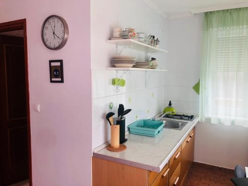 een keuken met een wastafel en een klok aan de muur bij Family 2-rooms Apartment in Hévíz