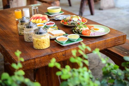 een houten tafel met borden met eten erop bij Theerama Cottage in Suan Phung