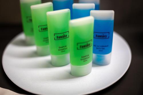 a group of green and blue bottles on a white plate at Annona Apartments in Bečej