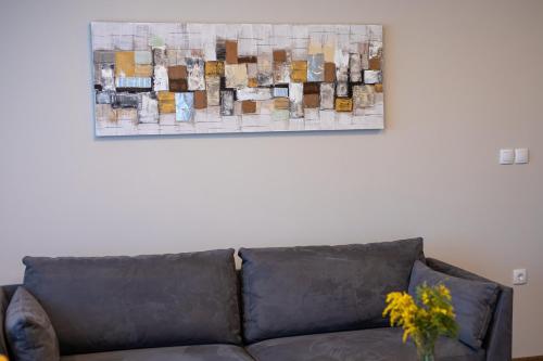 a couch in a living room with a painting on the wall at Annona Apartments in Bečej