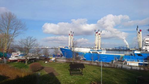 un gran barco azul está atracado en un puerto en Haus Warnowblick Objekt 36737 en Rostock