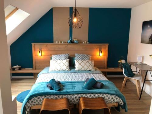 1 dormitorio con 1 cama grande y paredes azules en la chambre de lola, en Waterloo