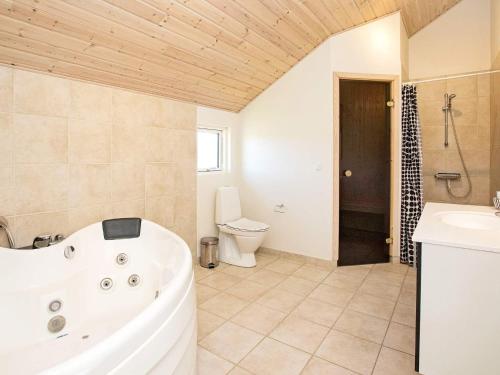 ein Badezimmer mit einer Badewanne, einem WC und einem Waschbecken in der Unterkunft Four-Bedroom Holiday home in Idestrup 3 in Bøtø By