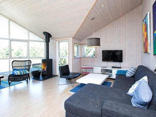 a living room with a couch and a tv at 9 person holiday home in V ggerl se in Bøtø By