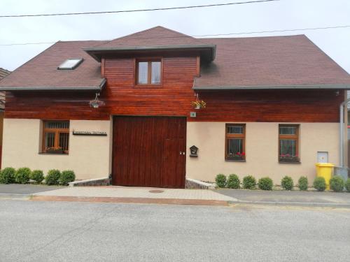 uma casa com uma porta de madeira numa rua em Apartmán Trstinka em Trstené