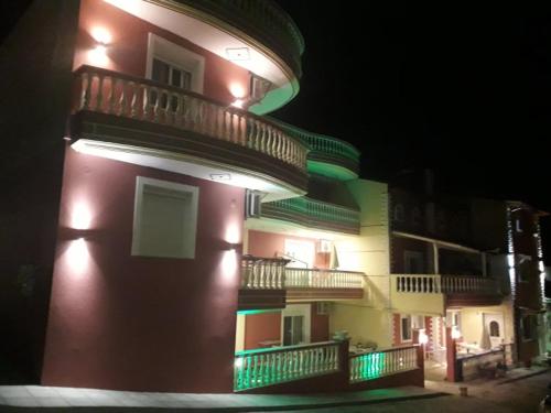 a building with lights on the side of it at night at petros house in Sarti
