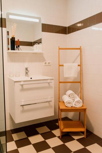 a bathroom with a sink and a mirror and towels at Hotel Steeds aan Zee in Katwijk