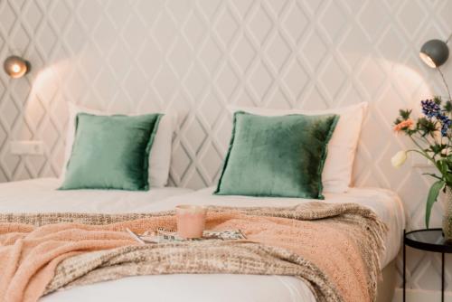 a bedroom with two beds with green pillows at Hotel Steeds aan Zee in Katwijk