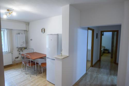 コンスタンツァにあるApartament Faleza Nordのキッチン(テーブル、白い冷蔵庫付)