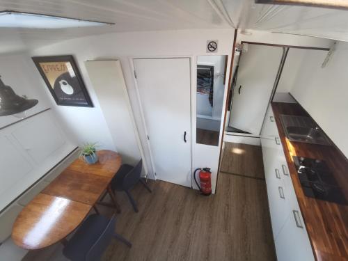 a small kitchen and dining room in a tiny house at Waterloo square river vieuw houseboat in Amsterdam